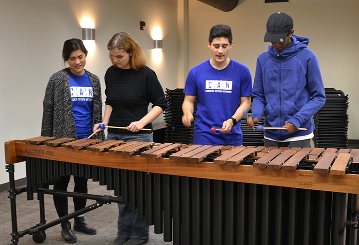 Support workers and teens with autism play a xylophone together in our Sarah McLachlan School of Music program.