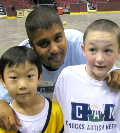 Two boys pose for a photo with their coach.