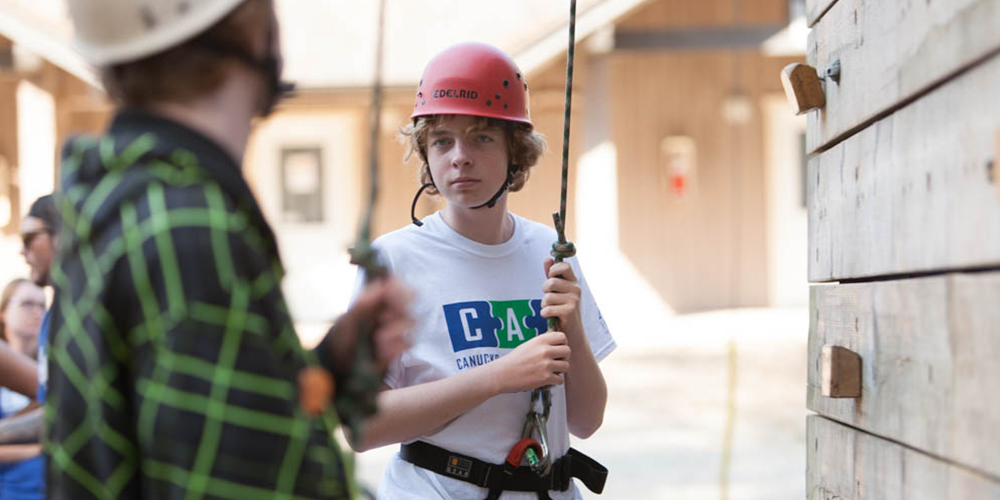 A youth male at a rock climbing wall