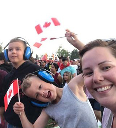 Family at a Canada Day celebration with Canadian flags and noise-cancelling headphones